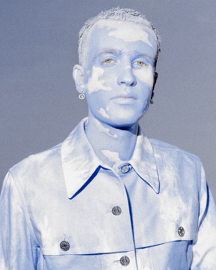 Jesse Clark with cloud themed facepaint photographed against a blue sky